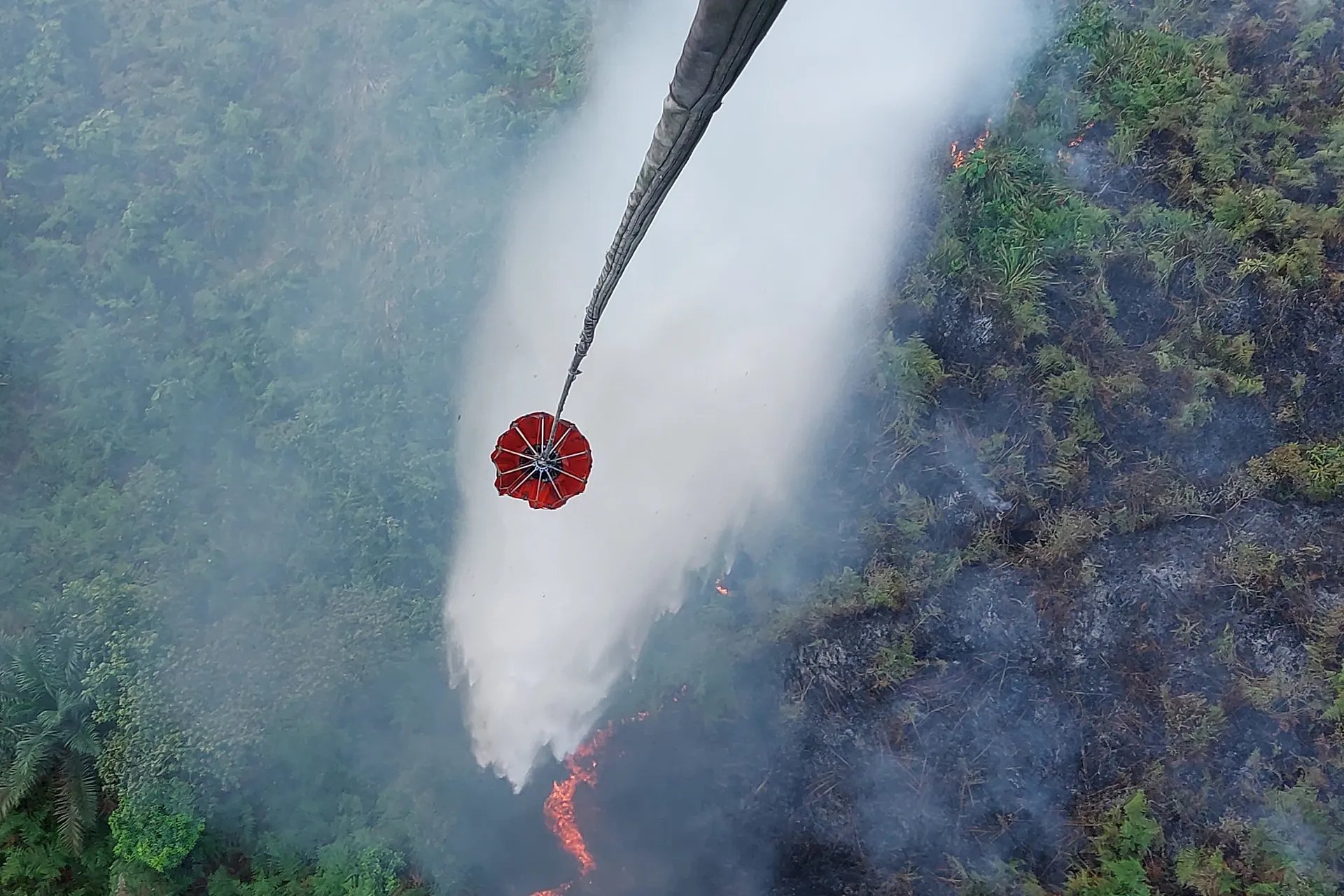 Danau Lamo'daki bir turbalık tarlasında devam eden orman yangınını söndürmek için bir helikopter su bombardımanı gerçekleştiriyor, 24 Ağustos 2026