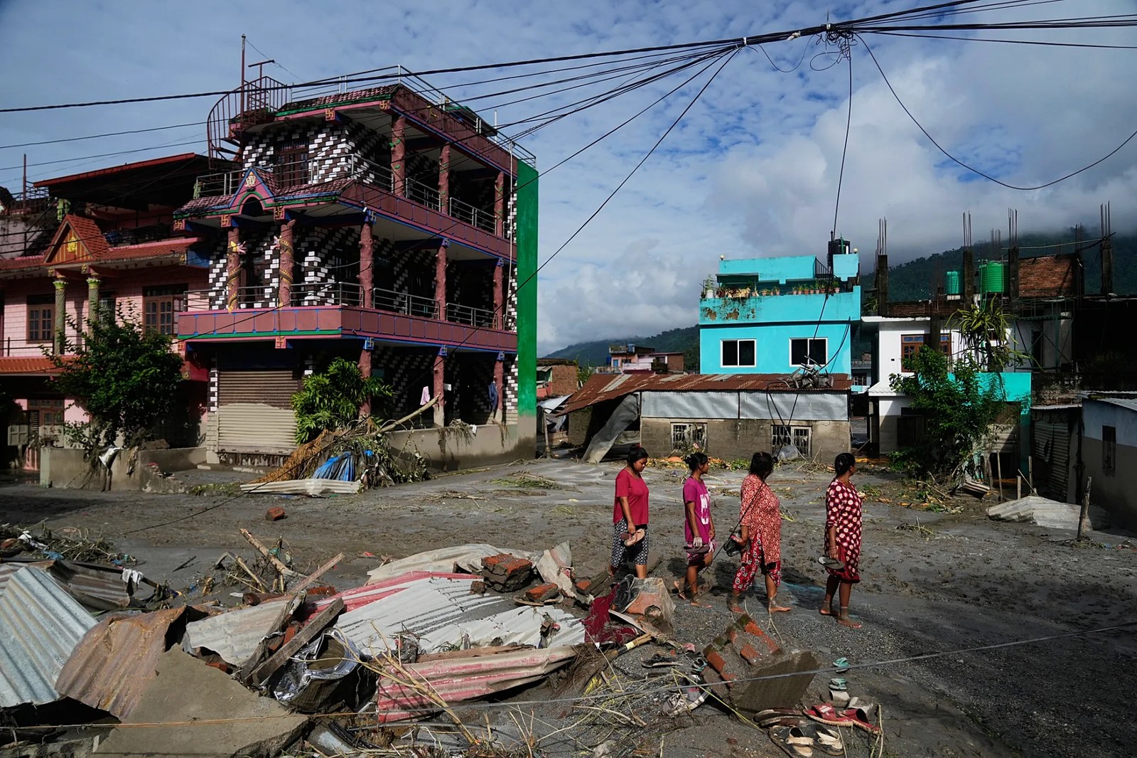 İnsanlar, Nepal’in Nuwakot bölgesindeki Devighat’ta ani sellerin ardından oluşan hasarın yanından geçiyor, 27 Ağustos 2026.