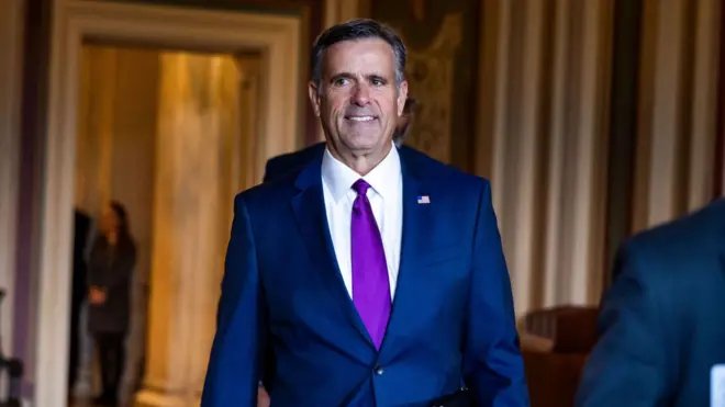 CIA Direktörü John Ratcliffe bu yılın başlarında Washington'da görüntülenmişti.  Remi giyimli ve gülümseyerek yürüyor.