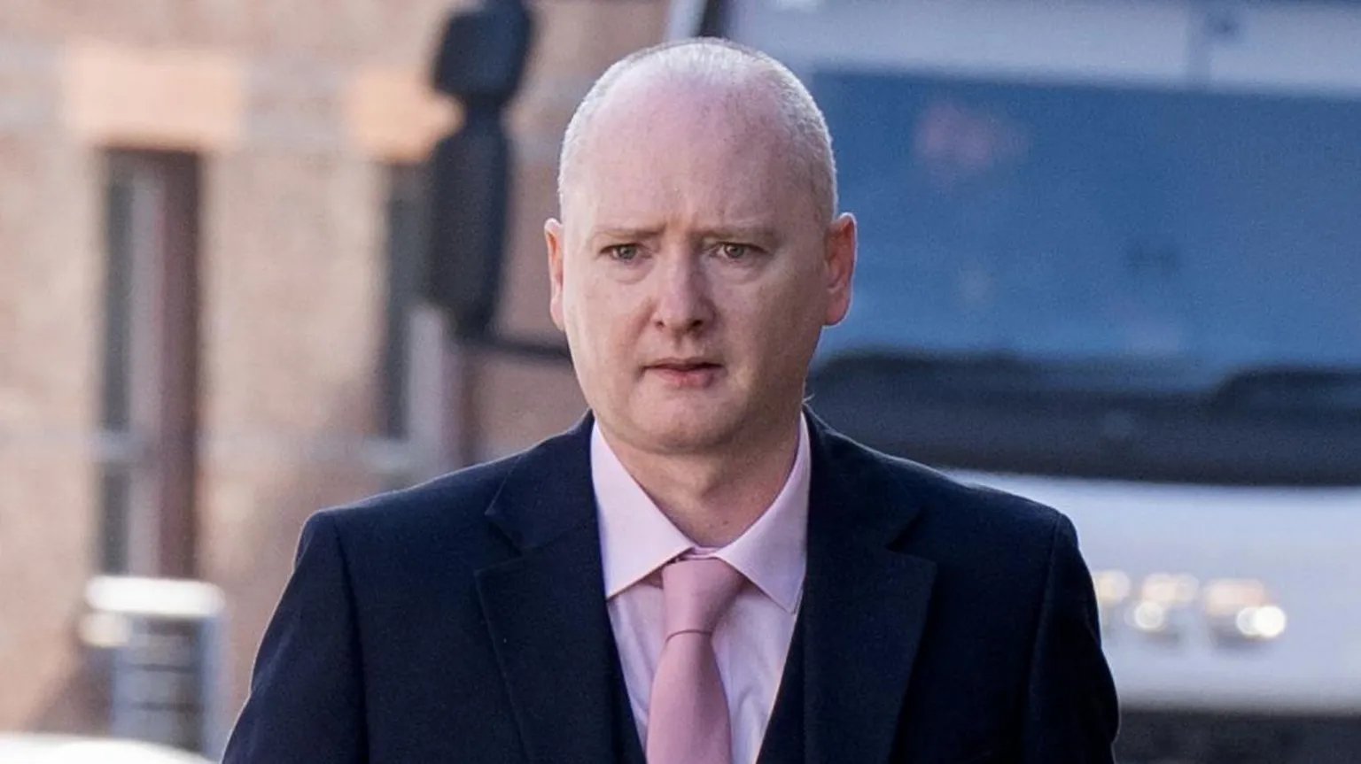 PA Media Graeme Dott arriving at the High Court in Glasgow. He is wearing a dark suit over a pink shirt witha pink tie.