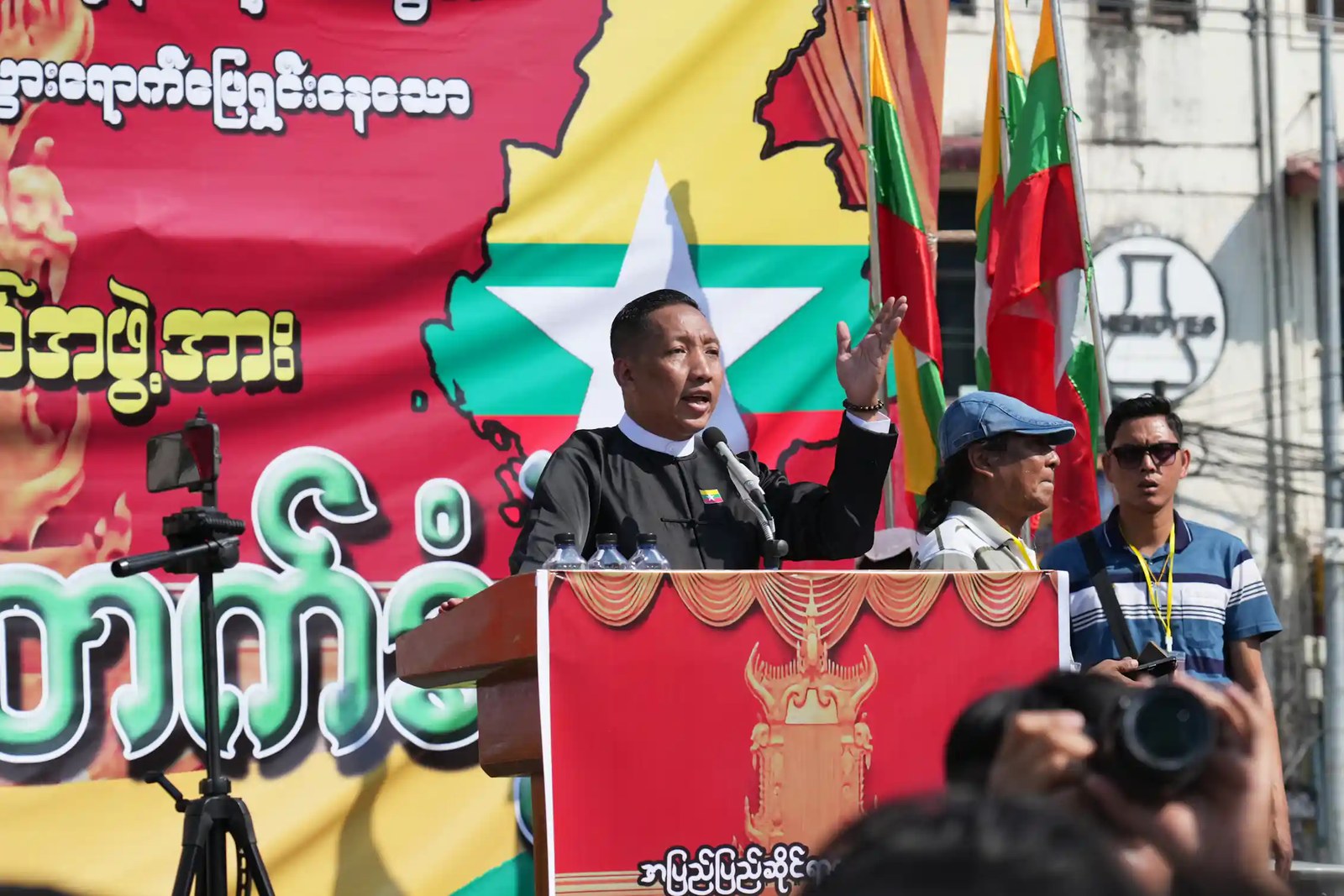 A man speaks into a microphone at a rally.