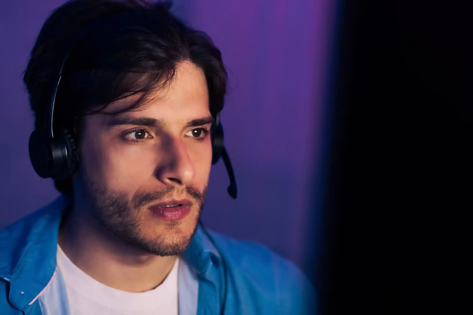Young man looking at screen wearing headset