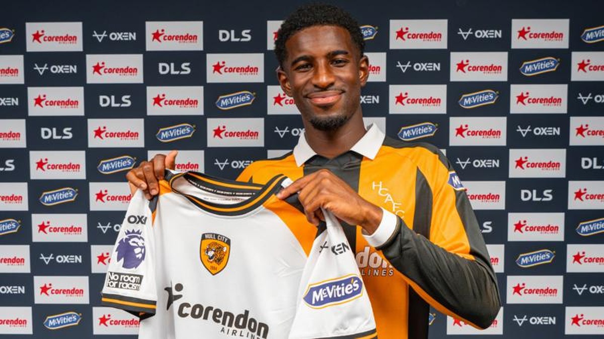 Hull City's new signing Mohamed-Ali Cho poses in the club's yellow and black home shirt, while holding up their white away strip