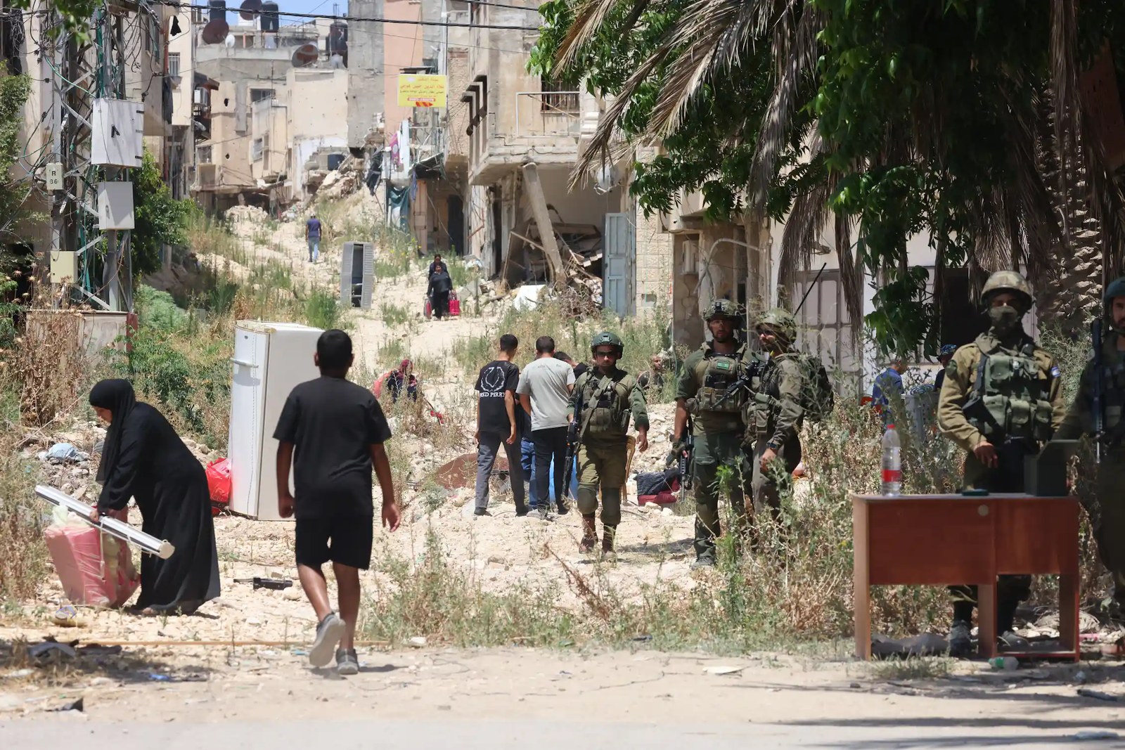 Israeli troops stand guard in a refugee camp for Palestinians.