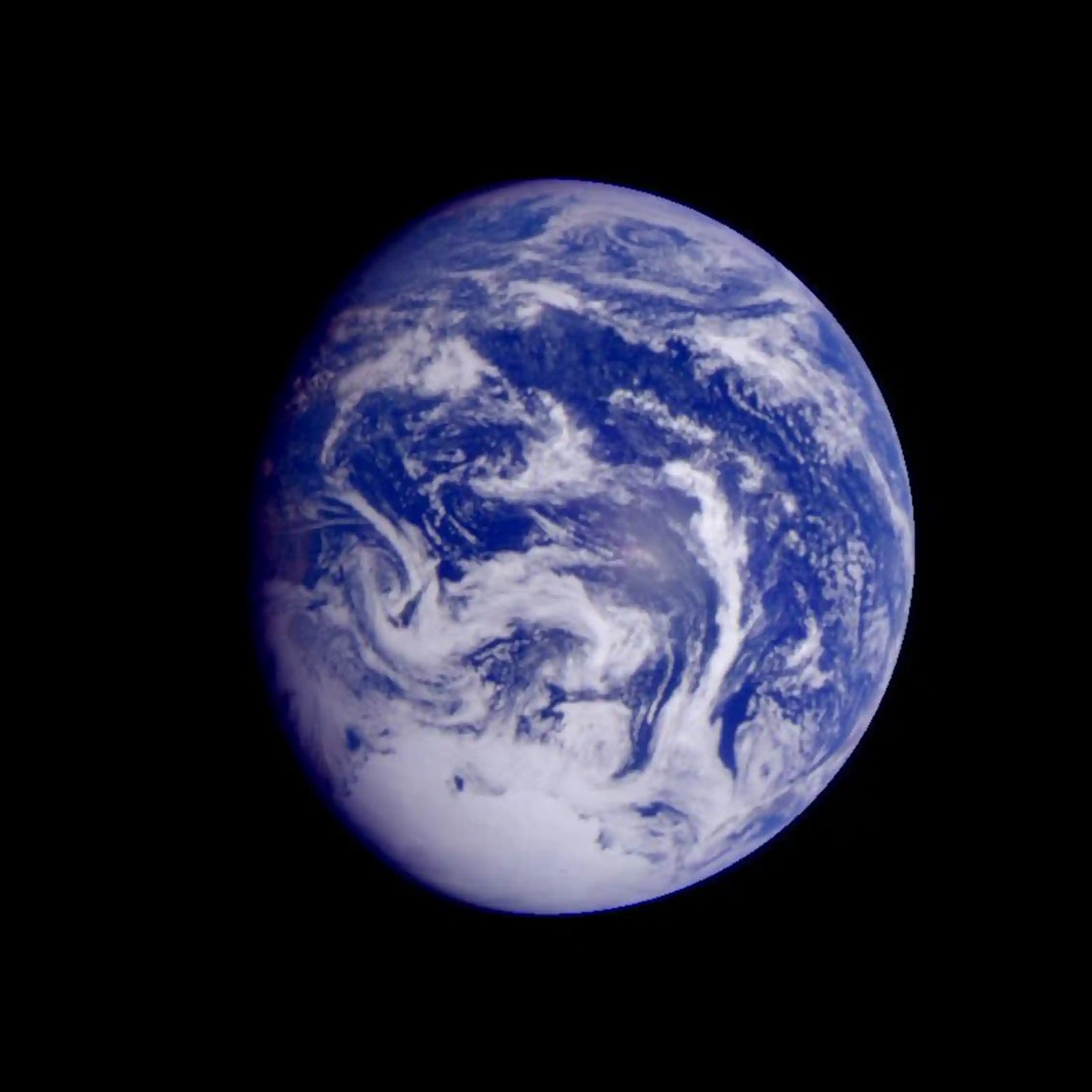 The Earth from afar, showing swirls of white on blue.