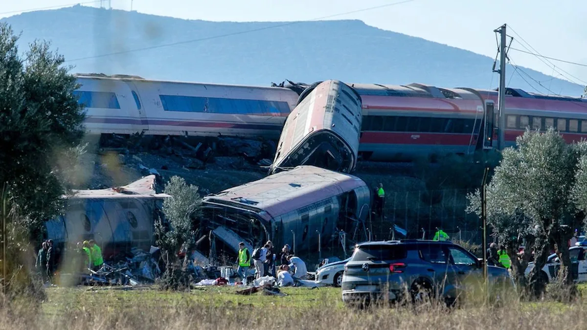 Two trains crashed into each other, with carriages falling down an escarpment as emergency services tend to them.