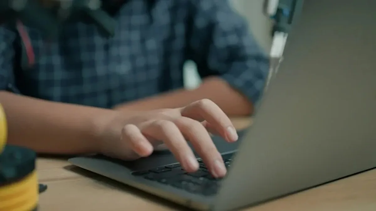 Close up hands typing on laptop.