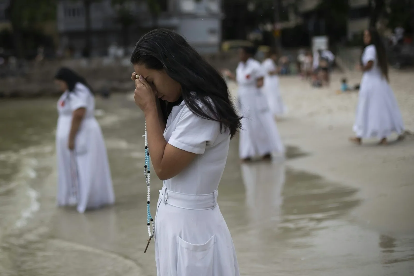 Devotees pray during an Umbanda religious ceremony at Urca beach in Rio de Janeiro on Dec. 30, 2023. AP Photo/Bruna Prado