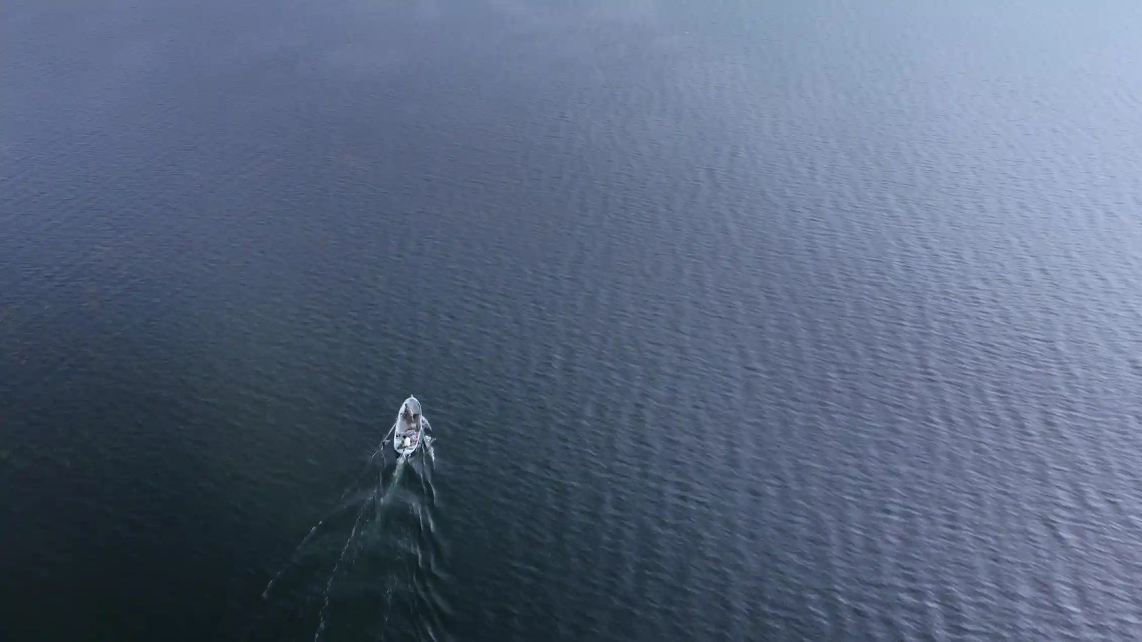 A small boat in a large expanse of water.