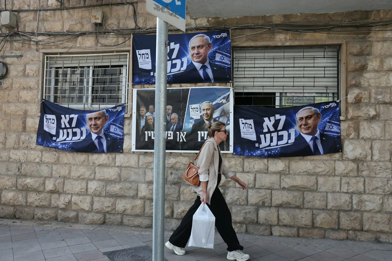 A woman passes an election billboard of the Israeli prime minister, Benjamin Netanyahu, in Jerusalem with a Hebrew slogan reading: ‘will not surrender’. Abir Sultan / EPA