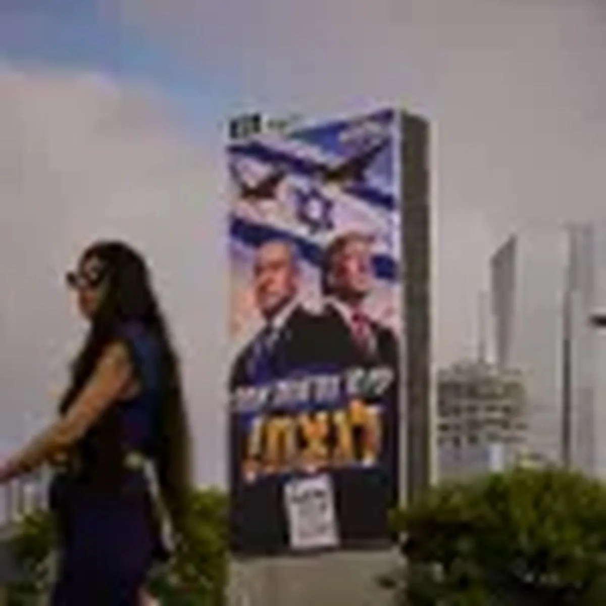 A woman walks past a Likud Party campaign billboard featuring President Trump and Israeli Prime Minister Benjamin Netanyahu, with a Hebrew message reading, "We have one opportunity to win," in Tel Aviv, Israel, on Monday.