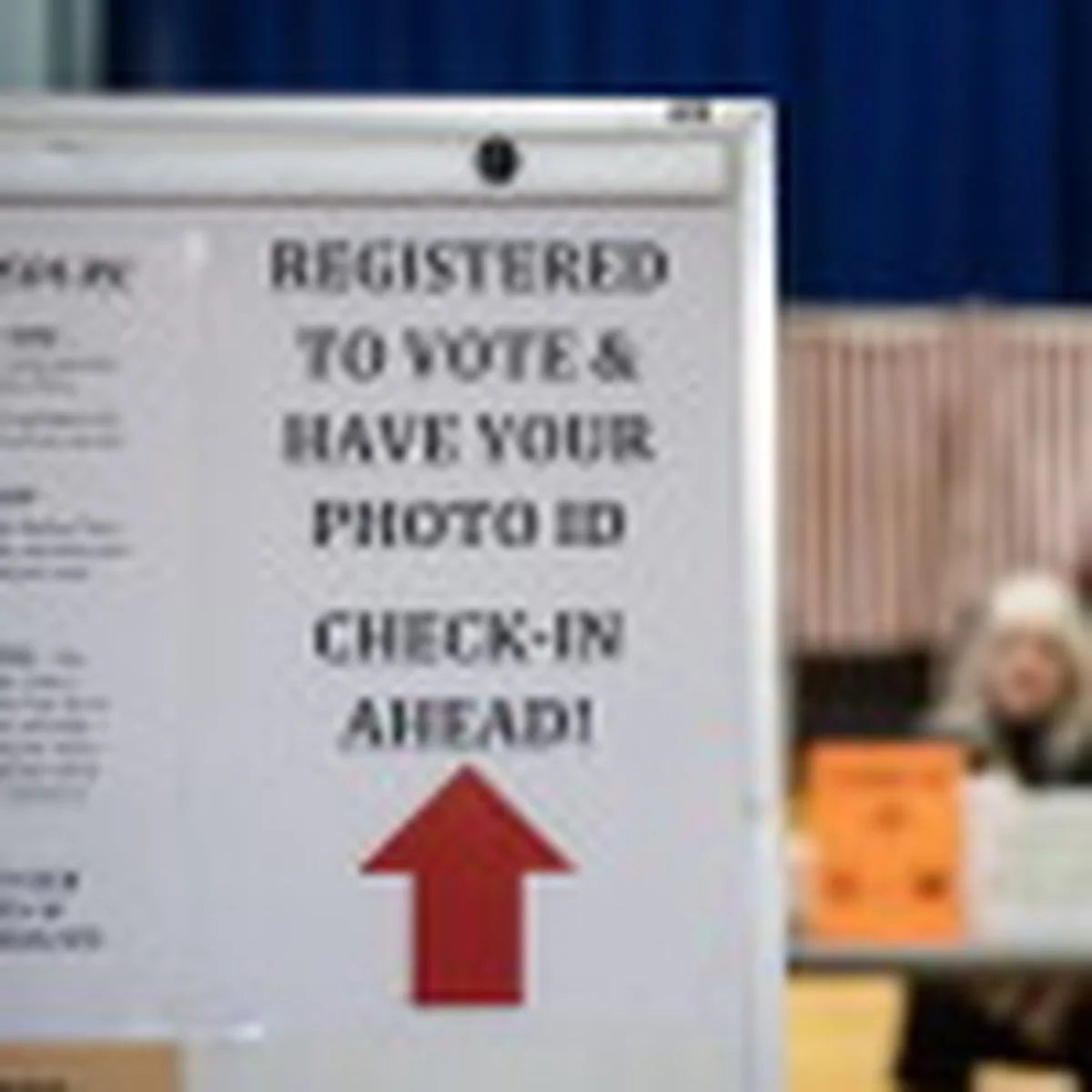 A sign informs registered voters to have their photo IDs ready to check in at a polling place in Lancaster, N.H., in 2024.