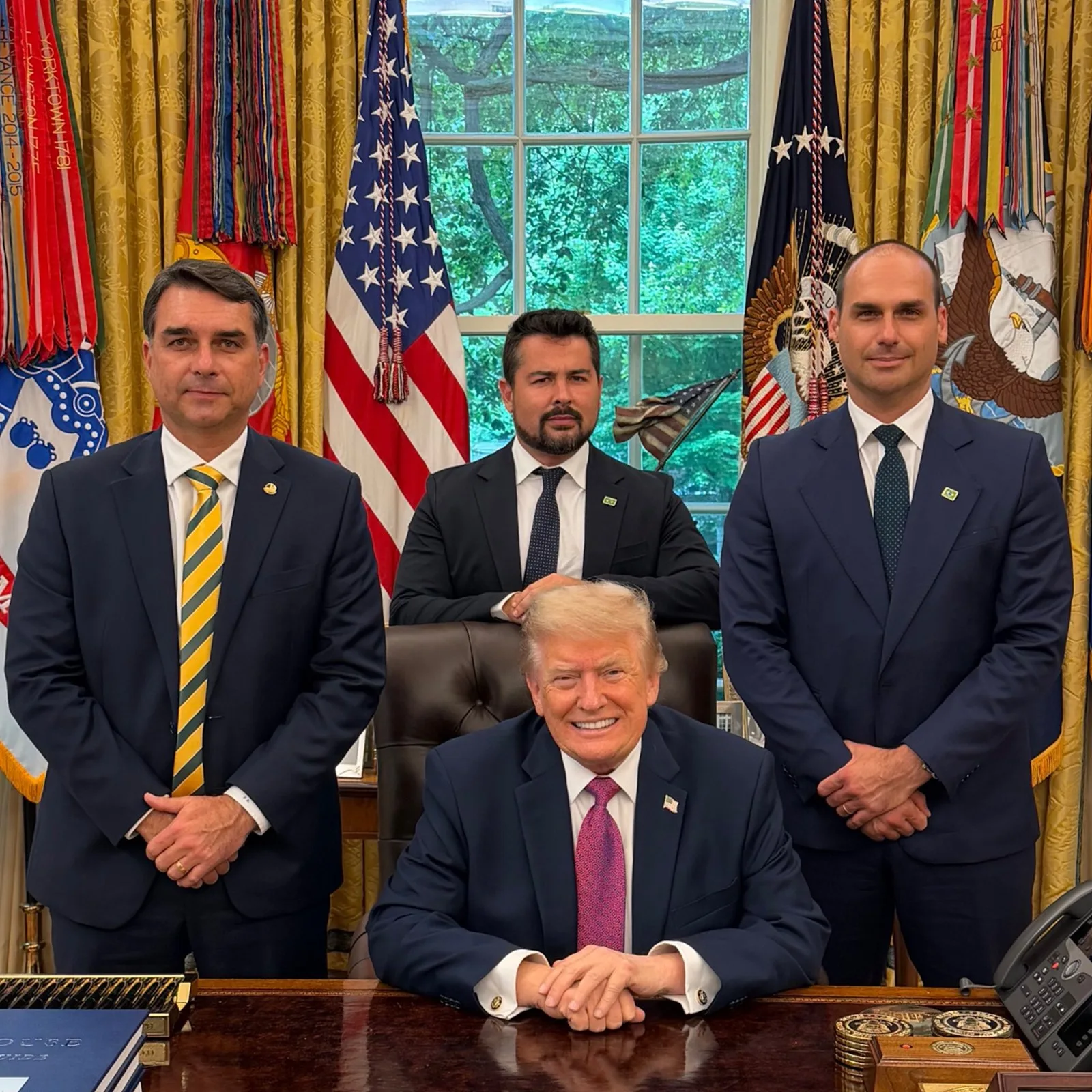 Brazil right-wing presidential candidate Flávio Bolsonaro (left) with President Donald Trump at the Oval Office in May 26, 2026: days after the meeting the U.S. government imposed a 25% extra tariff on imports from Brazil, a move largely attributed to an alleged requests by him, his brother Eduardo Bolsonaro (right) and far right blogger and influencer Paulo Figueiredo (center). Eduardo Bolsonaro/X