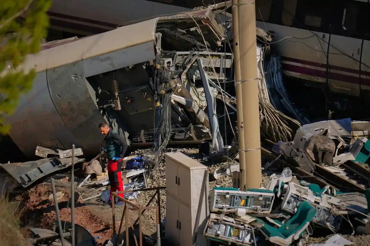 A Guardia Civil collects evidence from the wrecckage of a rail collision.