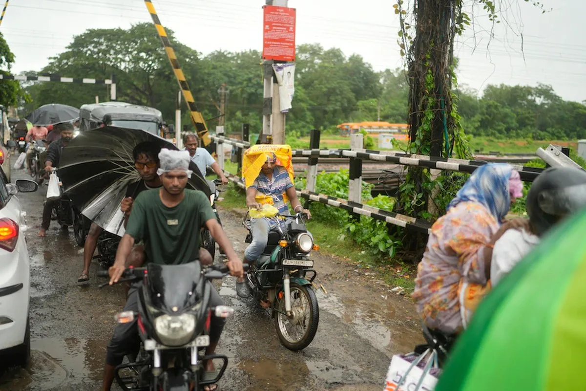 Motorists shield themselves from the rain while crossing railway tracks as a cyclone made landfall. 