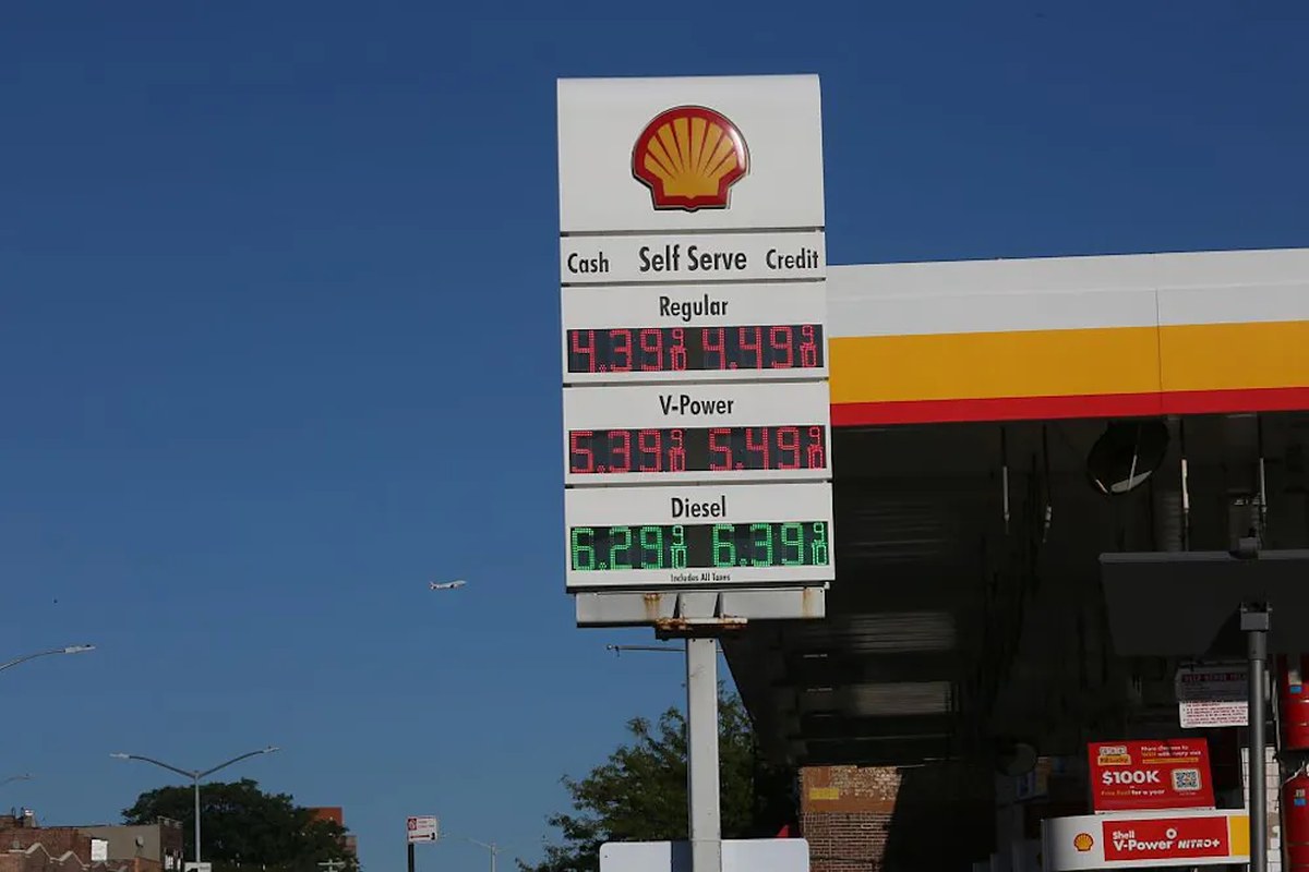 A Shell gas station sign lists gas prices.