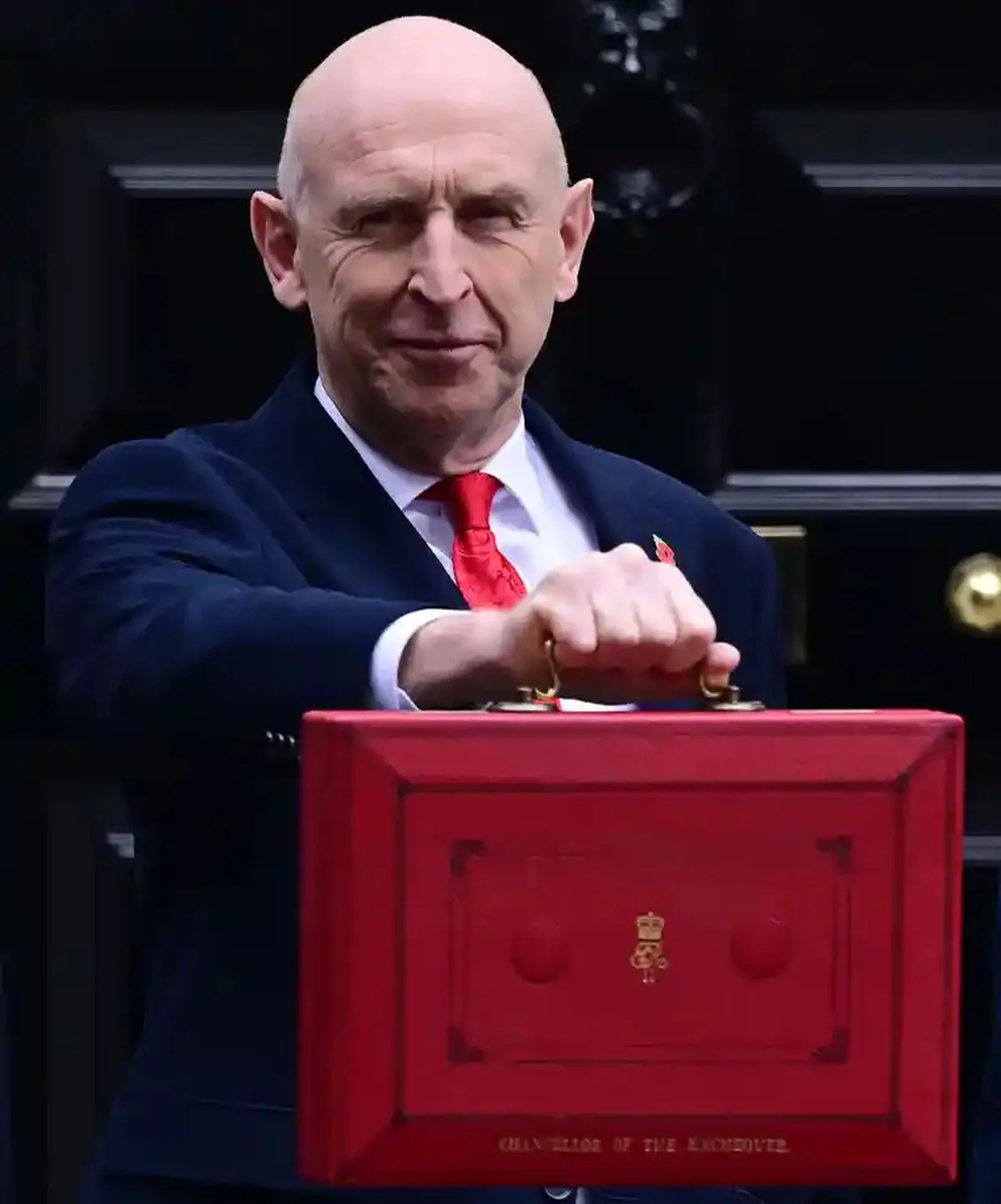 John Healey holds up the red box in Downing Street before going to the Commons for his budget