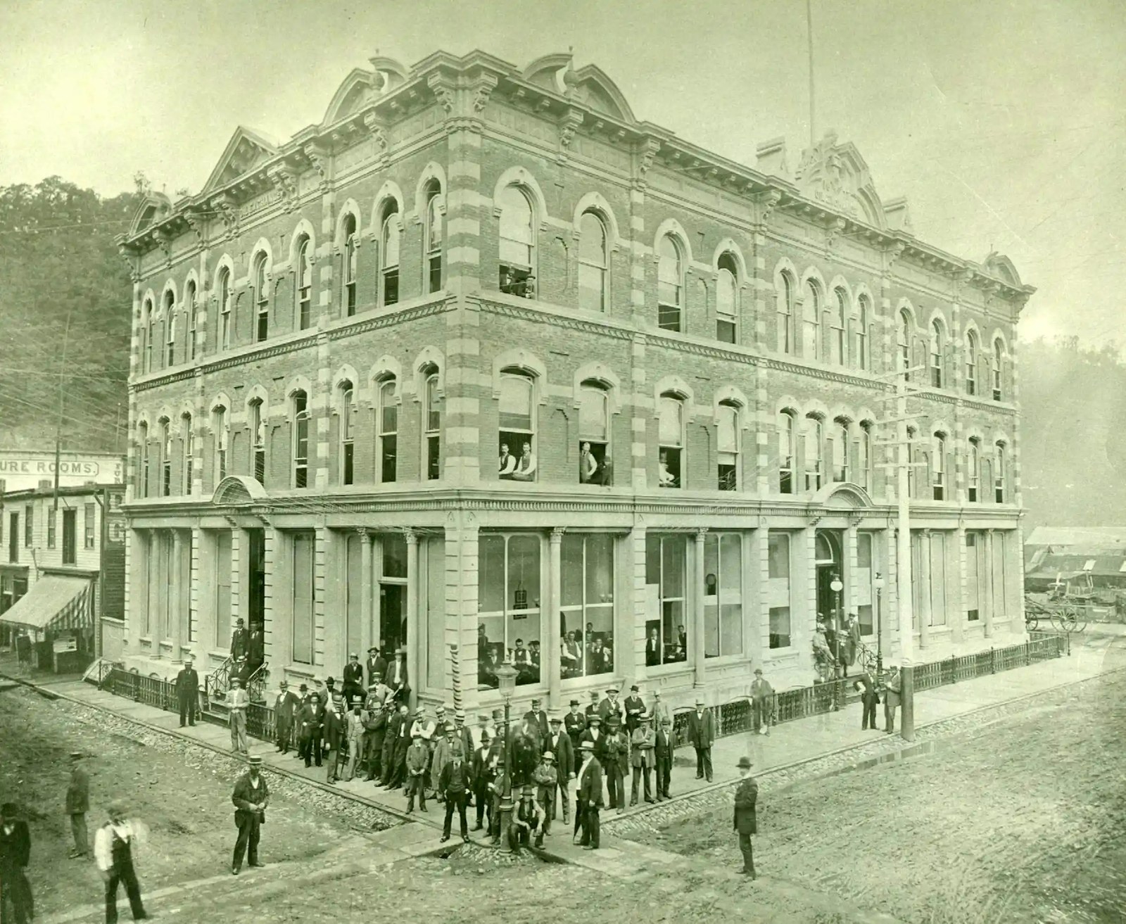 Businessmen are seen outside an ornate building in a black-and-white photo.