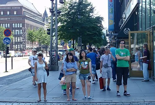 Pedestrians ready across the street next to the Forum shopping center in Helsinki, Finland